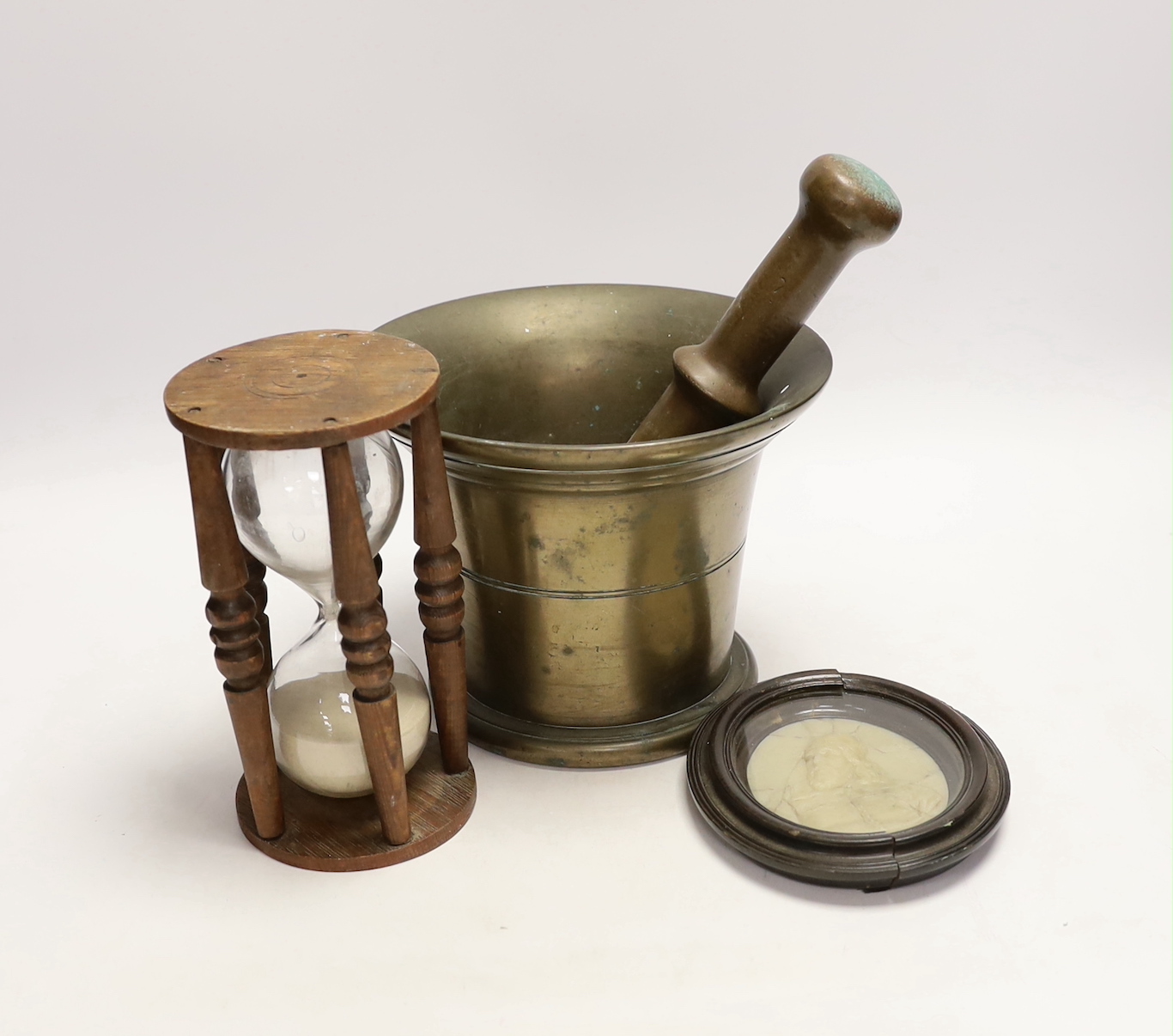 A bronze pestle and mortar, an hourglass and a wax portrait of Inigo Jones, mortar 15cm high